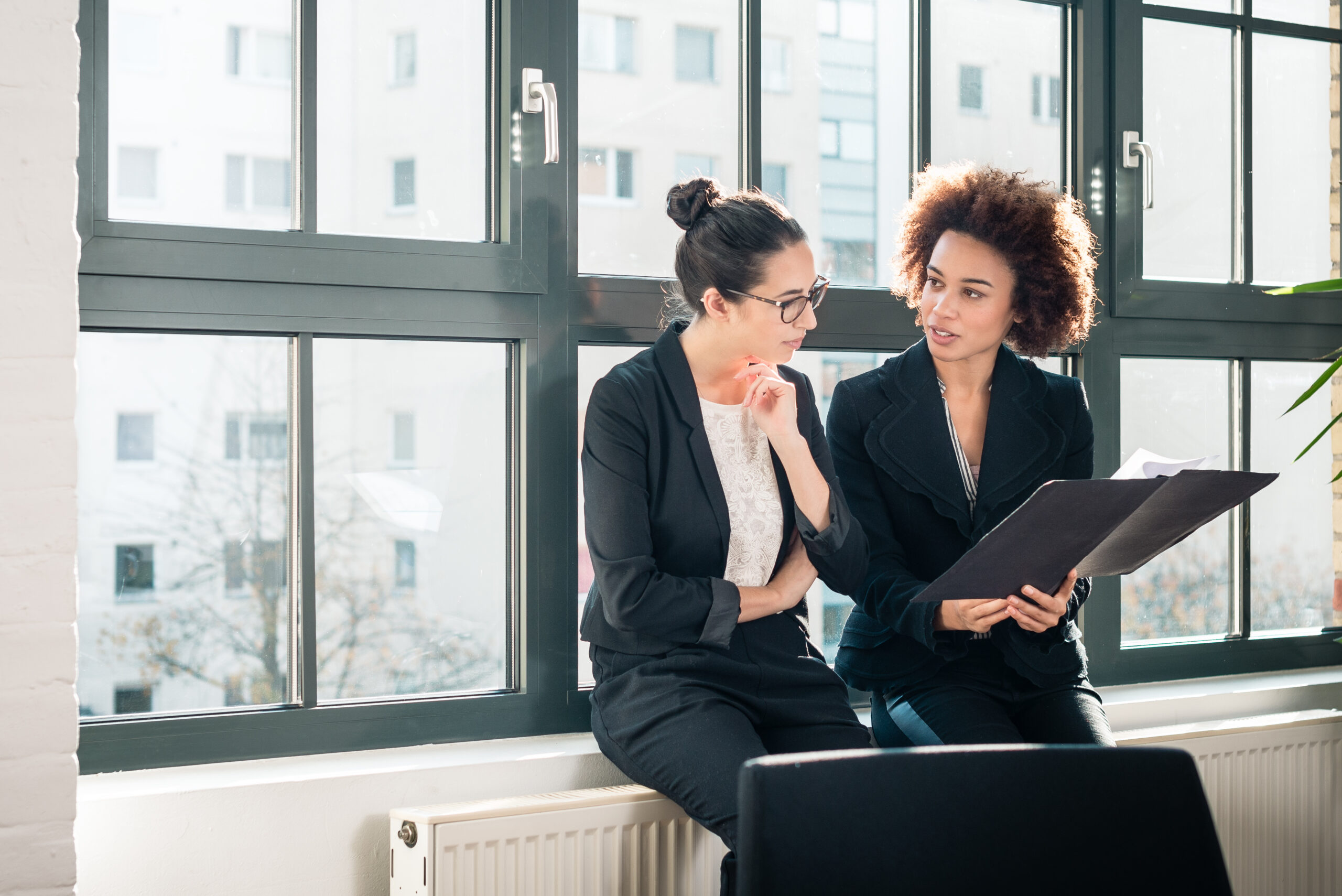 Two young colleagues reviewing business reports during break