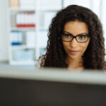 Serious young businesswoman reading the screen