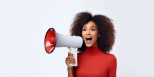 Excited lady holding loudspeaker while sharing news.